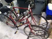 Two red Trek 720 bicycles side by side on metal stand in garage