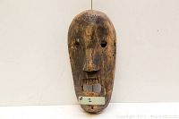 Front view of carved wooden mask showing overall shape and features