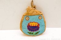 Front view of the Indigenous tobacco bag showing detailed beadwork floral design.