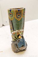 Angled full view of vase showing tapered form and peacock base