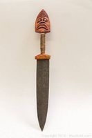 Full view of the dagger showing the long blade and carved wooden handle