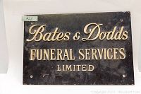 Full view of the black metal sign with cream embossed lettering 'Bates & Dodds Funeral Services Limited'