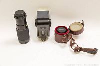 Overview photo showing three items: Cimco 100-300mm zoom lens, Vivitar 283 SB4 flash unit, Carl Zeiss Jena 28mm f/2.8 lens inside leather case