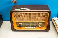 Front view of the vintage tube radio showing speaker grill, knobs, and push buttons.