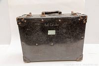 Front view of the black metal travel case showing Bell Canada logo and surface scratches.