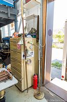 Two vintage floor lamps together, showing the taller brass lamp and the shorter brown lamp with green and white shades.
