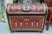 Front view showing red panels with gold-tone Egyptian reliefs and pharaoh mask