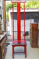 Front view of vintage Mackintosh style red wooden high back chair showing tall central back slat and curved top piece