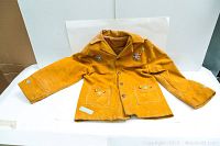 Full front view of vintage yellow moose hide coat with floral bead embroidery on chest and pocket areas