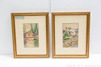 Pair of framed watercolour paintings side by side featuring house scenes