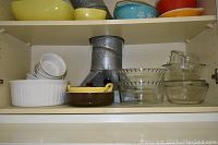 Image showing the shelf with 7 pieces including white ceramic baking dishes, clear glass bowls and smaller casseroles.