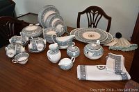 Full display of dinnerware pieces and linens on table