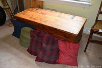 Full view of rustic cedar chest with cushions in front