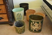 Full set of 6 garbage cans of various materials and colors placed on floor