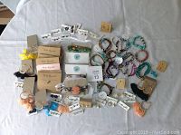 Top-down photo showing assortment of handmade bracelets and pairs of earrings spread on fabric surface.