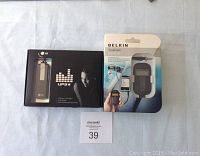 Photo showing LG UP3 USB MP3 player box and Belkin TuneCast Universal FM Transmitter box side by side on a surface.
