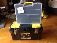 Photo showing a 19-inch Stanley toolbox with metal latches and a clear plastic carrying case with yellow handle placed on top.