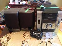 Photo shows Sony main stereo system with 3 CD changer and cassette player, two large speakers, and one small portable speaker on a table.