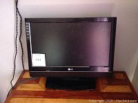 Front view of 20 inch LG TV showing screen, LG logo, and power cord plugged into an outlet.
