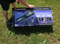 Original Celestron NexStar 130 SLT box showing model name and telescope graphic, photographed outdoors on grass