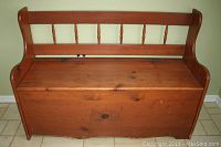 Front view of wood storage bench showing overall structure and spindle backrest