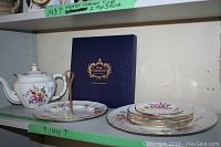 Shelf view with teapot, box, plates and two-tier stand