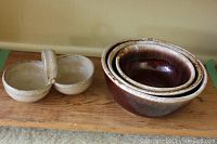 Photo showing Meg Buckley Salt Spring Island pottery and three McCoy Pottery nesting bowls on a wooden surface