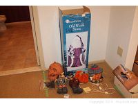 Photo showing various Halloween decor items including faux pumpkins, Halloween plush figures, a small Halloween accent, and the Old World Santa in box.