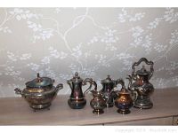 Overall view of the entire silverplate set showing all six items, including coffee and tea pots, sugar bowl, creamer, and a large tureen.