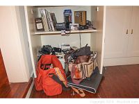 Wide shot of lower shelf and floor cabinet showing multiple vintage camera bags.