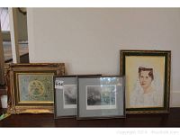 Three framed art pieces displayed on a table showing different frame styles and subjects.