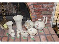 Wide view of vases, trinket box, and angel figurine on brick hearth.