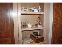 Shelf view showing ceramic figurines and decorative items including porcelain girl with dogs, and Asian decor on the middle shelf.
