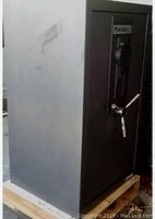 Safe exterior on wooden pallet showing dark gray steel body and chrome handle