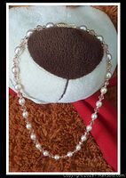 Necklace draped over a stuffed animal showing the pearl and bead arrangement and clasp