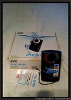 JVC PICSIO GC-WP10 digital camera with original box and warranty card on a white background.