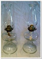 Pair of complete glass oil lamps standing upright with chimneys assembled.