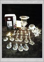 Photo showing Sussex Crystal Vase next to its original box along with 15 assorted chandelier crystal pieces of various shapes and sizes, all clear crystal.