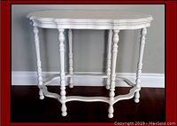 Front view of white painted spindle leg side table showing turned spindle legs and scalloped edges.