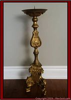 Full view of brass altar candle stick standing upright against wall
