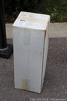 Original white cardboard box containing the car cover, showing some wear from storage.