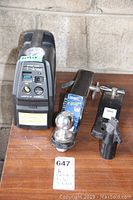 Campbell Hausfeld tire inflator and three trailer hitch components including one Reese hitch ball mount with chrome ball and two black metal hitch adapters