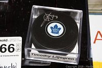 Clear view of autographed hockey puck with Toronto Maple Leafs logo and Timothy Liljegren signature inside display case.