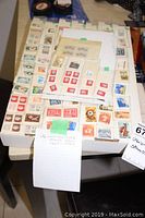 Full view of the stamp collection showing various sheets and stamps neatly arranged on a table.