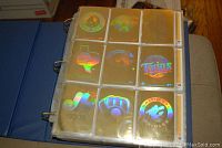 First photo showing binder displaying front sides of baseball cards with holographic foil logos and team icons.