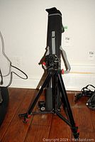 Full view of the Ideal Stabilizer tripod standing upright with carrying case behind
