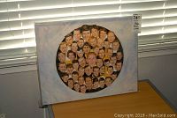 Full view of the 16x20 inch canvas print with multiple portraits arranged in a circle showing Boston Bruins players, placed on a desk with window blinds in the background.