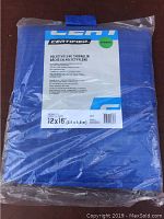 Blue polyethylene tarp in original sealed packaging, size and brand label visible