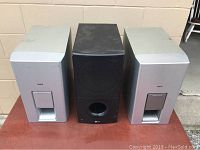 Three subwoofers visible: two silver Bose subwoofers and one black LG subwoofer