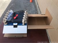 Top view of Bell HD Receiver 6400 with remote and power cable on molded protective cardboard inserts placed atop the original Bell box, alongside the outer cardboard shipping box.